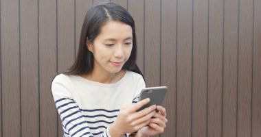 Elinde cep telefonu kullanan kadın