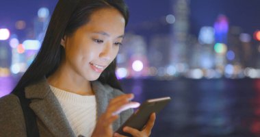 Cep telefonu Hong Kong şehir içinde geceleri kullanarak iş kadını 