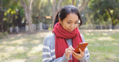 Kış döneminde cep telefonu kullanan kadın 