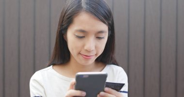 Alışveriş için cep telefonu kullanan kadın 