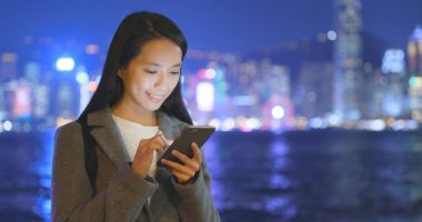 Cep telefonu Hong Kong şehir içinde geceleri kullanarak iş kadını 
