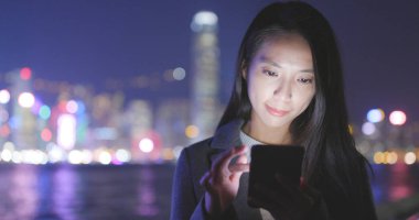 Cep telefonu Hong Kong şehir içinde geceleri kullanarak iş kadını 