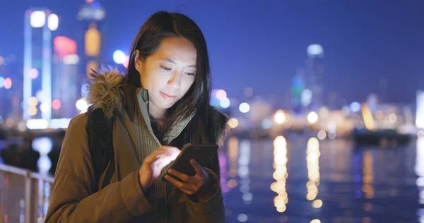 女人晚上在城市中使用手机 — 图库照片