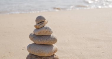 Zen taşlar bir kum plajı üzerinde  