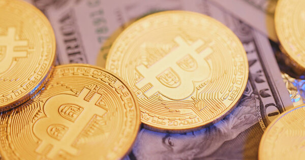 Bitcoins and USD banknotes close up