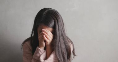 Gri arka plan üzerinde ağlayan depresyon kadın  