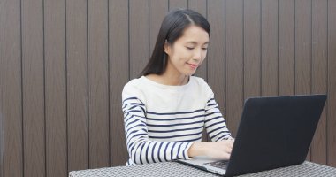 Açık kafede dizüstü bilgisayar üzerinde çalışan kadın 