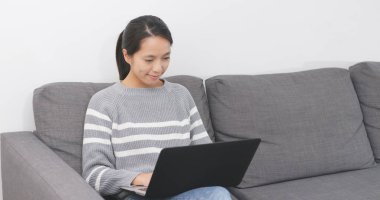 Evde dizüstü bilgisayar üzerinde çalışan kadın 