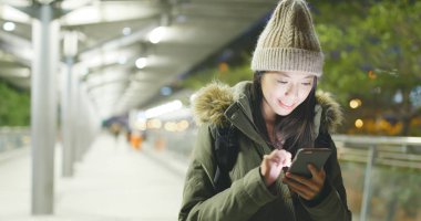 Kış ceket giyiyor ve cep telefonuyla şehirde kadın 