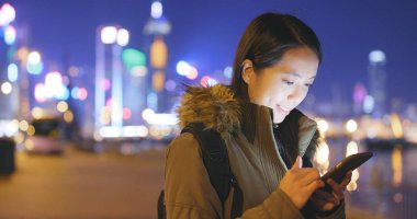 Geceleri cep telefonu kullanan bir kadın. 