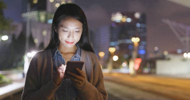 Gece akıllı telefon kullanan bir kadın. 