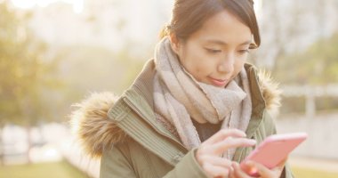 Günbatımı zamanı altında Smartphone kullanan kadın 