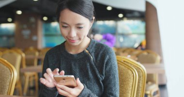 Kafede cep telefonu kullanan kadın