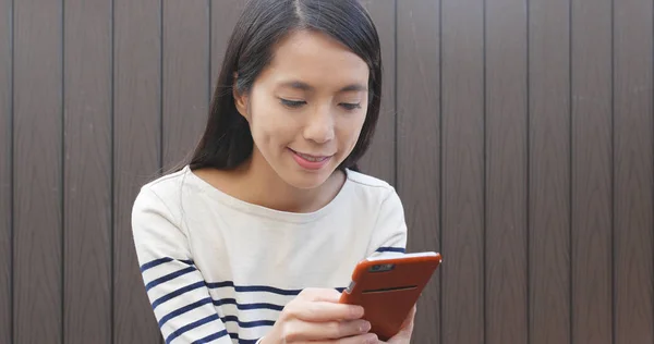 Mujer Mira Teléfono Inteligente Sonriendo —  Fotos de Stock