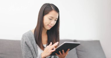 evde tablet bilgisayar kullanan kadın