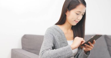 Evde cep telefonu kullanan bir kadın 