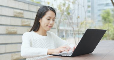 Açık kafede dizüstü bilgisayar kullanan kadın 