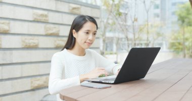 Açık kafede dizüstü bilgisayar kullanan kadın 