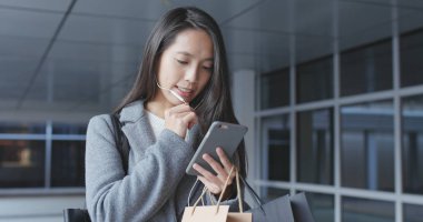 Cep telefonu kullaranarak ve kağıt torba tutarak işkadını 