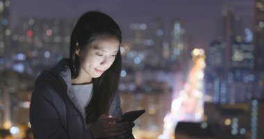 Geceleri şehri cep telefonu kullanan kadın 