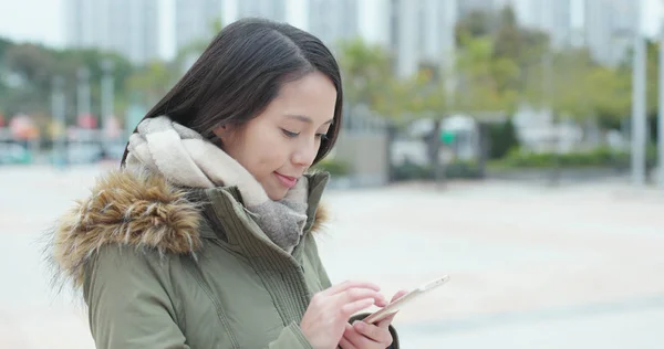 公园里的年轻女子在手机上看书 — 图库照片