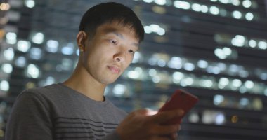 Geceleri cep telefonu kullanan adam. 