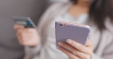 Online alışveriş için evde cep telefonu kullanan kadın 