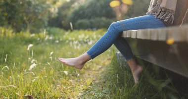 Ahşap yol ve salıncak bacaklar kenarında oturan kadın