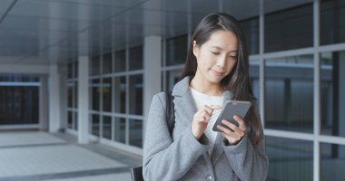 Genç işkadını cep telefonu açık, kullanarak 