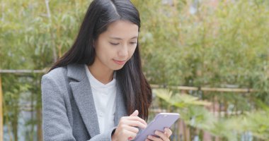 Yeşil arka plan üzerinde cep telefonu kullanarak iş kadını 