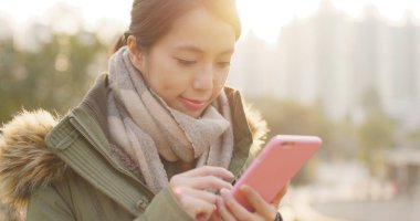 Güneş patlaması altında Smartphone kullanan kadın 