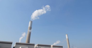 Endüstriyel fabrika baca ve duman mavi gökyüzü üzerinde 