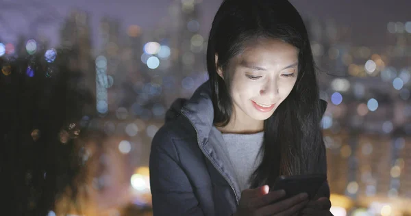 Mujer Usando Teléfono Celular Sobre Ciudad Por Noche —  Fotos de Stock