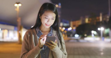 Gece akıllı telefon kullanan bir kadın. 
