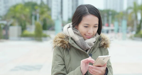 公園で携帯電話で読む若い女性 — ストック写真