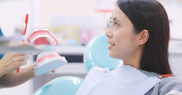 歯科医院で歯を磨く方法を患者に示す歯科医 — ストック写真
