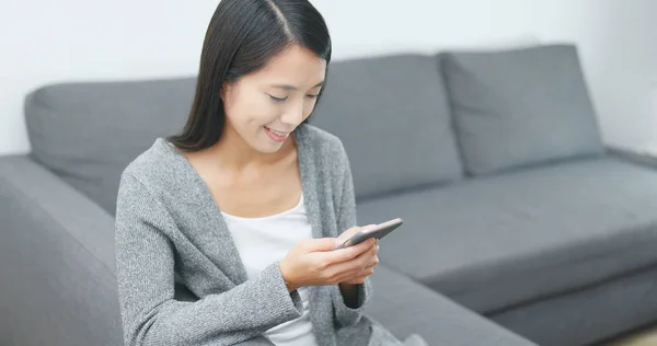 Woman play mobile game on cellphone at home