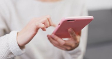 Evde cep telefonu kullanan bir kadın 