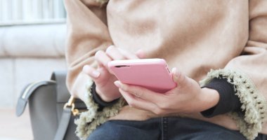 Şehirde akıllı telefon kullanan bir kadın 