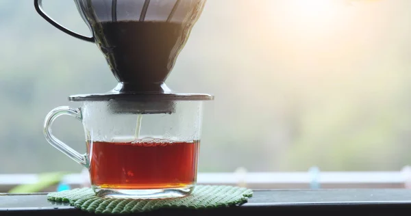 Making drip coffee over green background