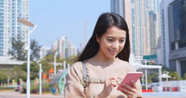 Kadın cep telefonuna bakıyor.