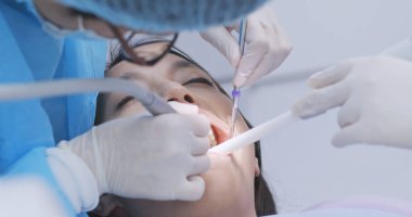 Dentist examines the patient teeth  clipart