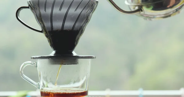 Making drip coffee over green background