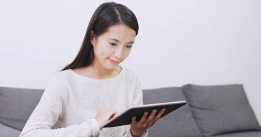 Asyalı kadın evde tablet bilgisayar kullanma 