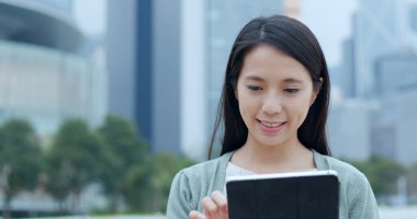 Tablet bilgisayar kullanan Asyalı kadın 