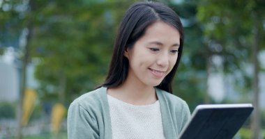 Şehirde tablet bilgisayar kullanan bir kadın. 