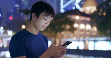 Smartphone şehirde geceleri kullanan adam 