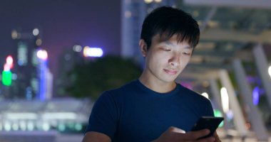 Smarphone şehirde geceleri kullanan adam 