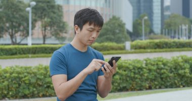 Genç adam şehirde cep telefonu kullanıyor. 