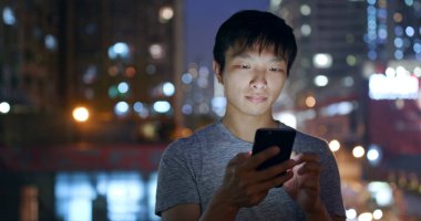 Adam cep telefonuyla Hong Kong şehir içinde geceleri 